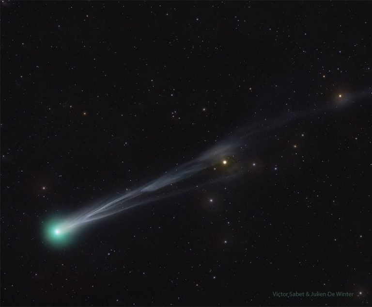 Comet Lemmon illuminating the night sky with its distinctive green coma and long tail
