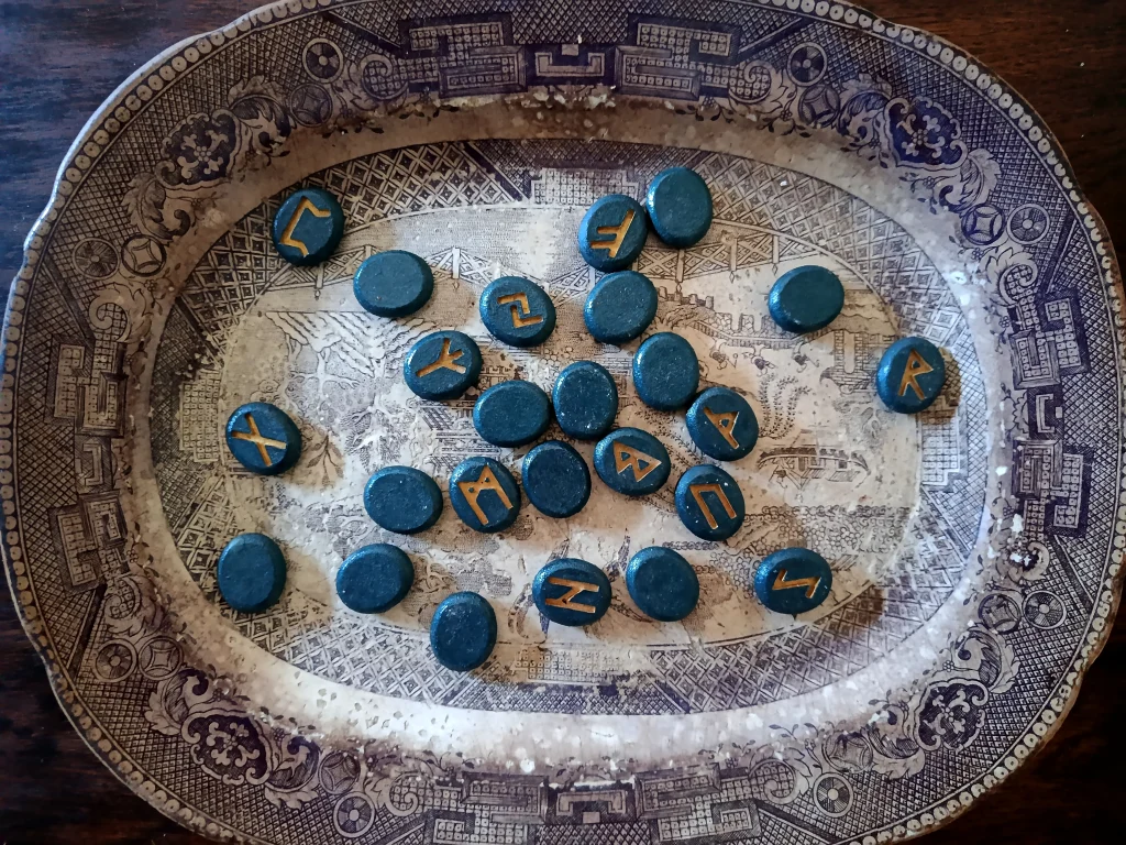 Runes arranged on a decorative plate during a divination practice.