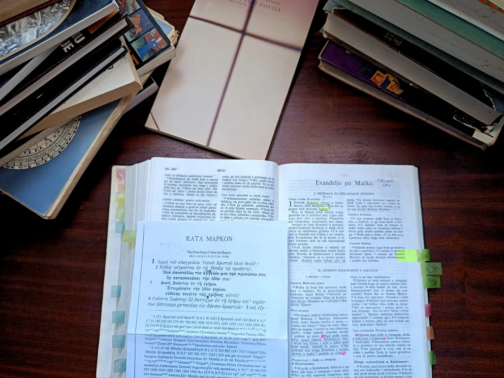 Open book surrounded by study materials used for theological and symbolic research.