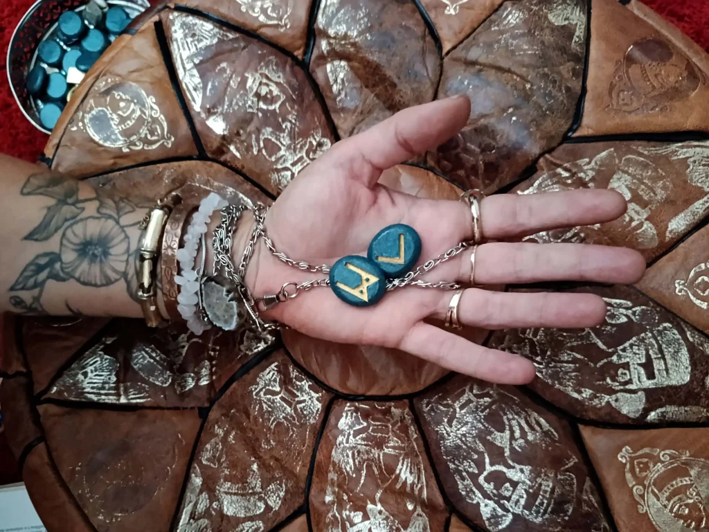 Hand holding carved runes used for symbolic divination and interpretation.