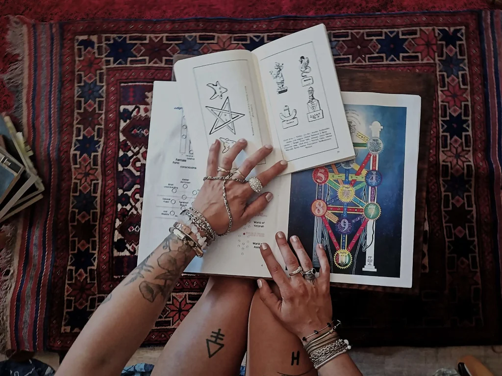 Books and symbolic illustrations used for research into mythology, astrology, and esoteric traditions.