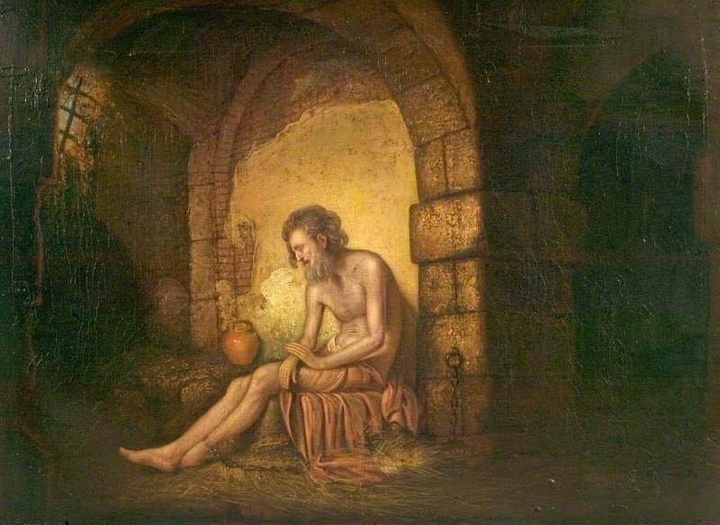 Solitary man in dark clothing standing inside a stone prison cell beside a barred window and narrow beam of light.